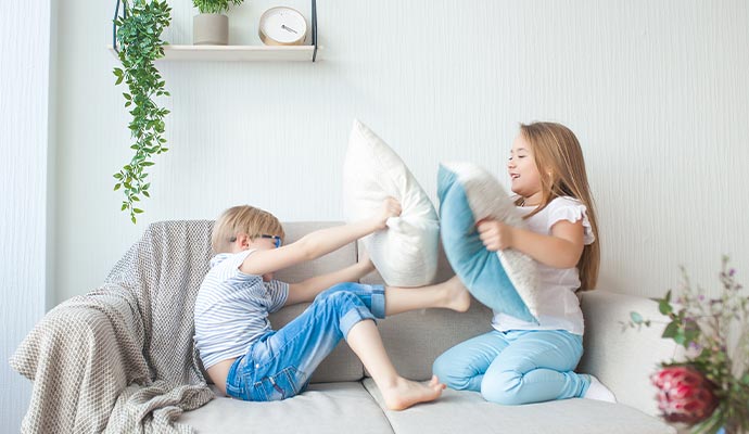 kids playing with loose pillows
