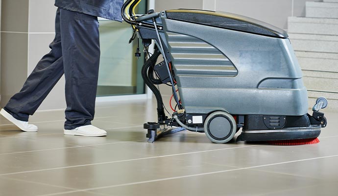 Professional worker cleaning the floor with Scrubber machine