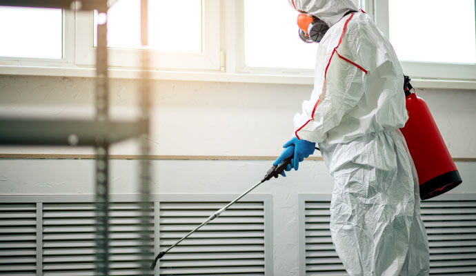 A person disinfecting a commercial area