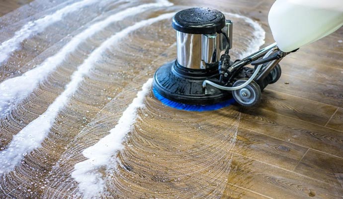 Professional cleaning wood floor using equipment