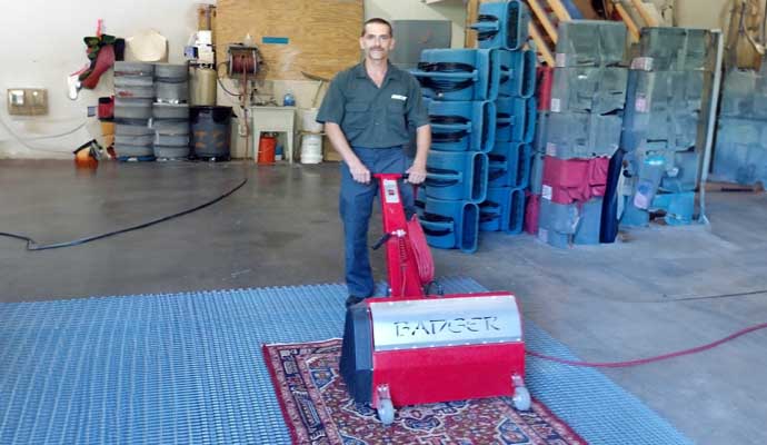 Person cleaning rug with rug cleaning machine