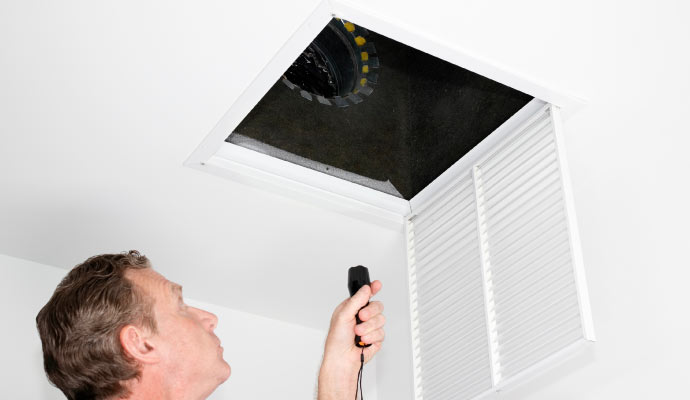 professional worker inspecting air duct