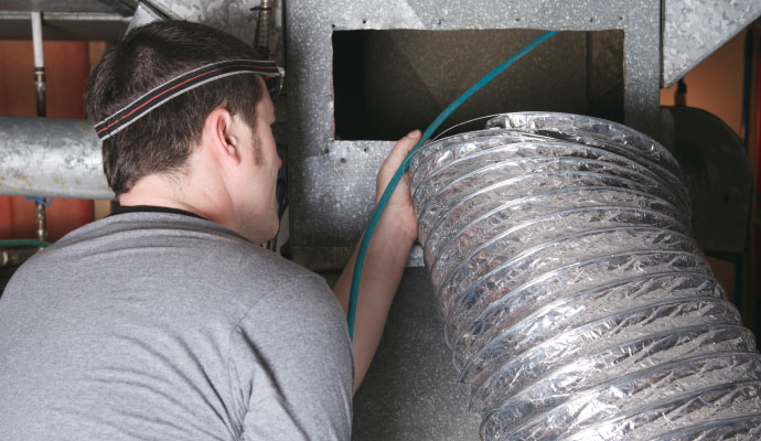 professional worker cleaning air duct vent