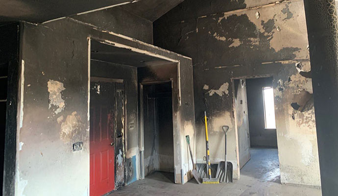 a fire-damaged room with blackened walls and ceiling