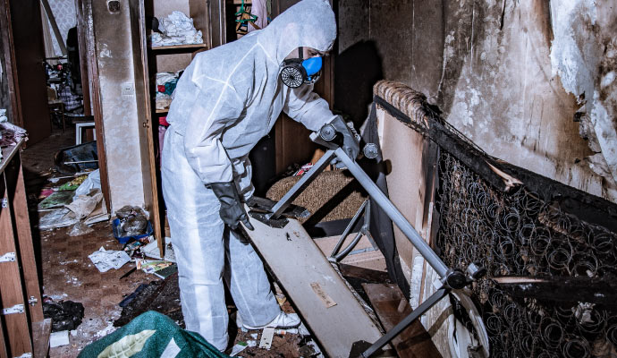 professional worker cleaning a fire-damaged room