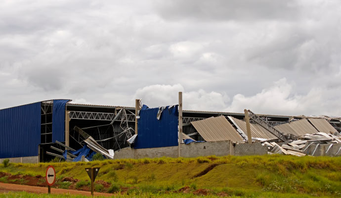 A warehouse with significant structural damage caused by a storm